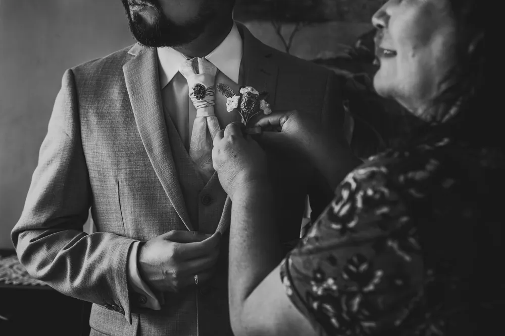 Le ponen la flor en la solapa al novio