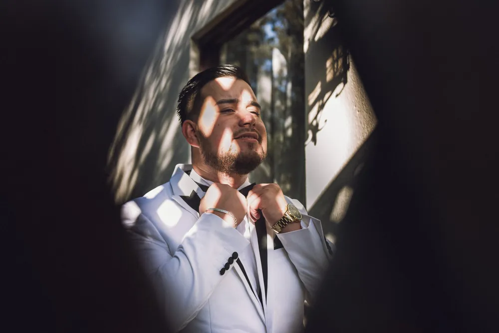 El novio se arregla la humita junto a la ventana