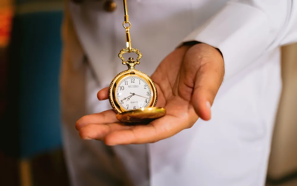 Un reloj de bolsillo en la mano del novio