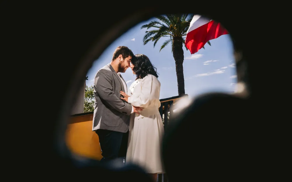 Los novios frente a frente con la bandera chilena de fondo